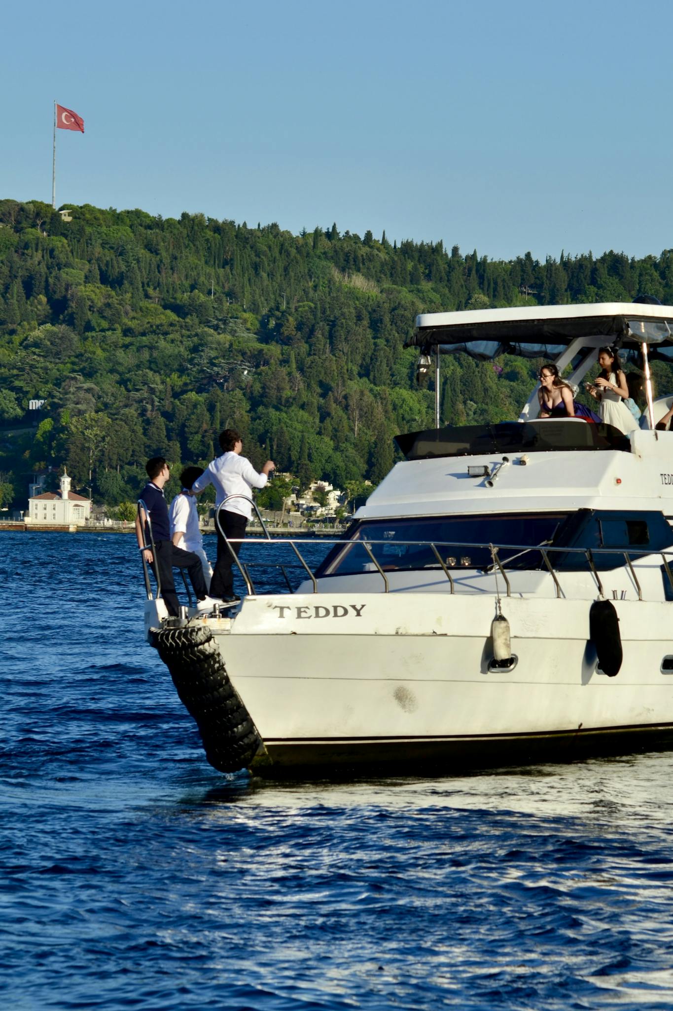 Elegant yacht on Bosphorus with passengers enjoying the scenic Istanbul view.